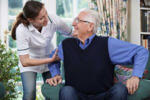 Older adult reviewing a monthly care budget with a family member at a kitchen table.