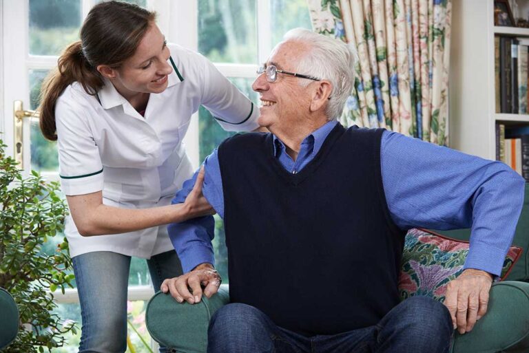 Older adult reviewing a monthly care budget with a family member at a kitchen table.