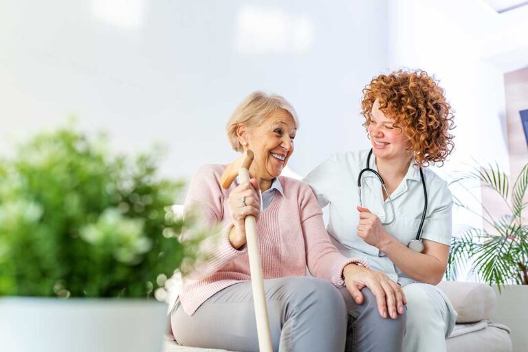 Older adult and family member review Medicare paperwork at a kitchen table beside a pill organizer.